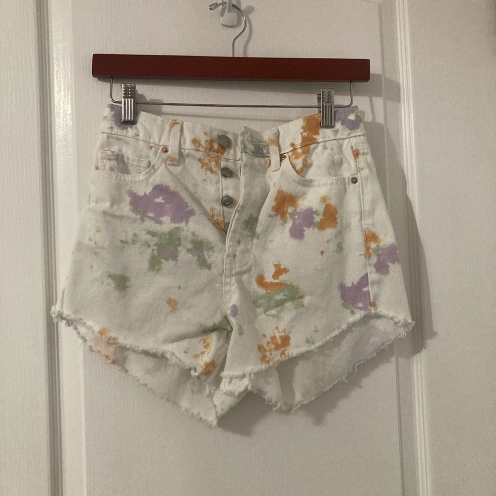 distressed white color splash jean shorts.